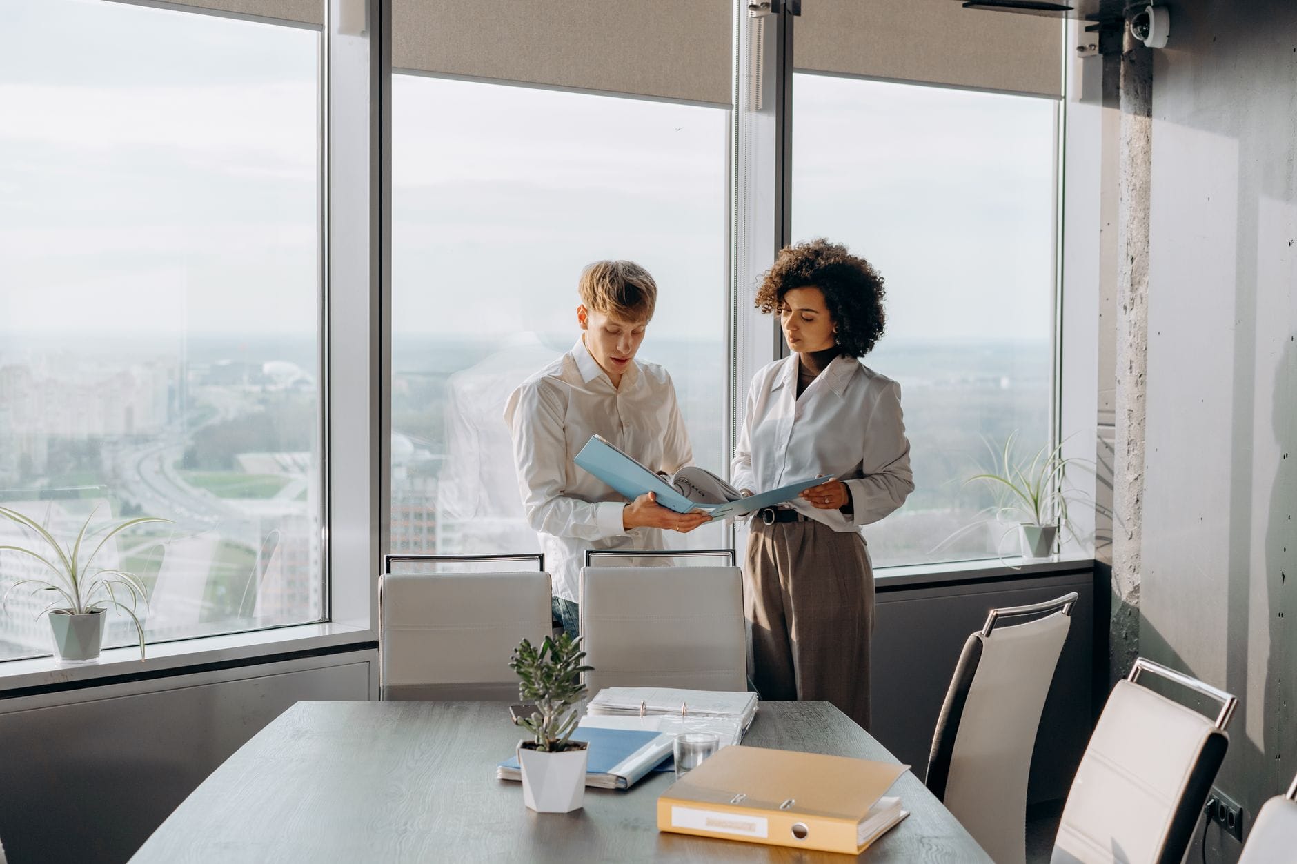 Two advisors reviewing a client file in a bright office