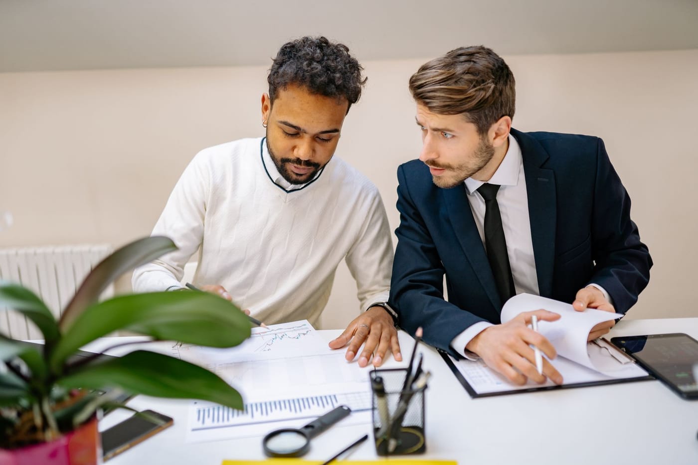 Two colleagues working through figures together at a desk